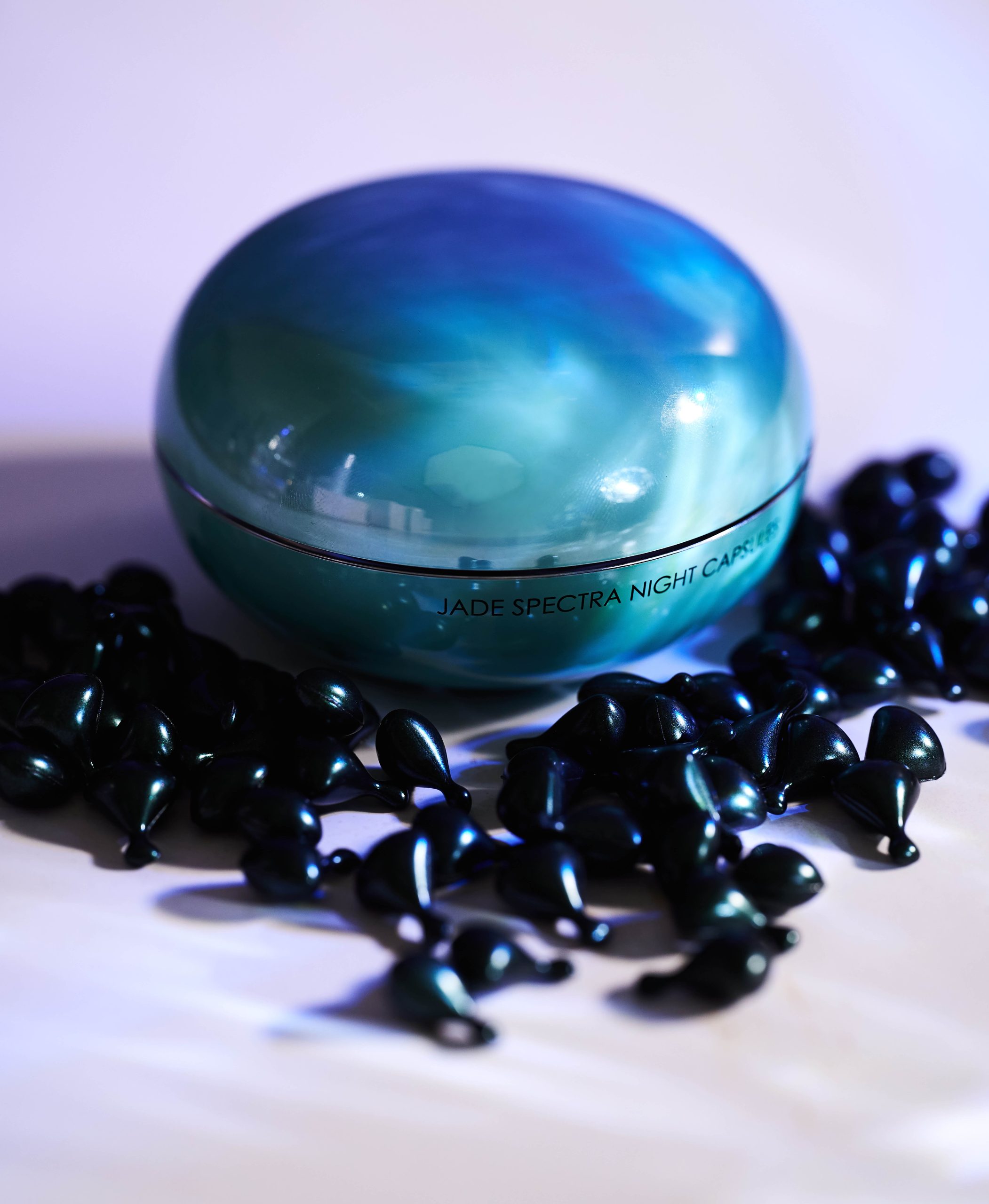Closed jar of Celestolite Jade Spectra Night Capsules with capsules on the table around it